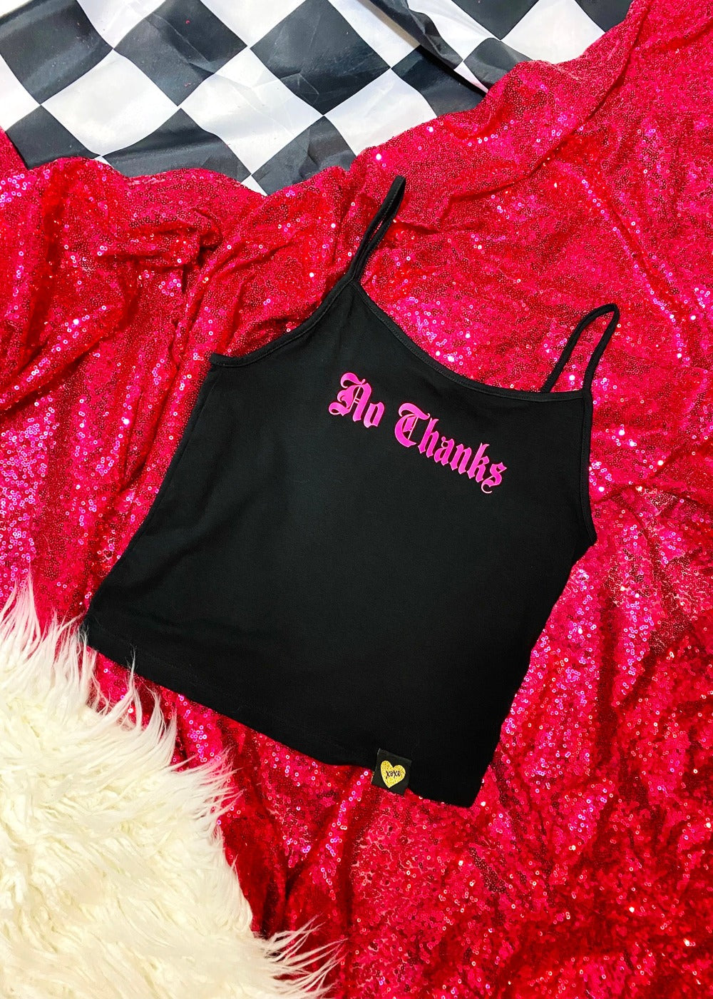 black spaghetti strap tank top on a hot pink sequin background