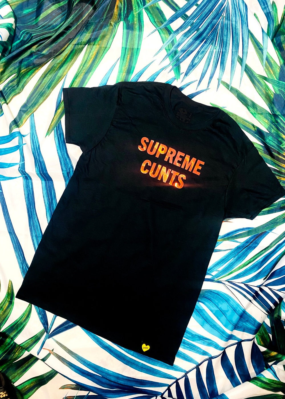 black graphic t shirt on a palm background full view