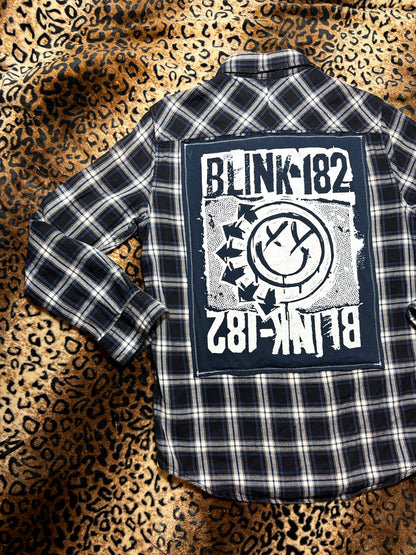 Plaid shirt with Blink-182 logo on a leopard print background