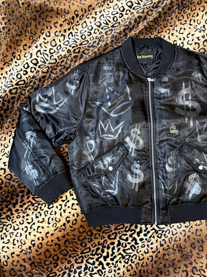 Black bomber jacket with silver graphics on a leopard print background