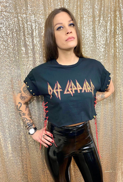 def leppard crop top on tattooed model with black vinyl pants in front of gold background