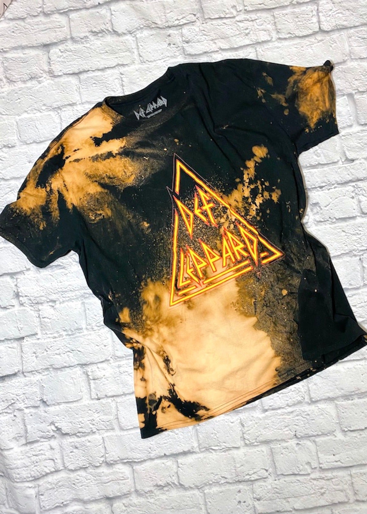 def leppard bleach dye oversized t shirt on a white brick background