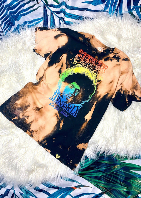 jimi hendrix black and rainbow bleach dye t shirt on a white furry and palm background shot from above