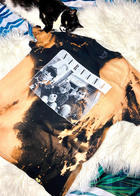 nirvana band photo on black bleach dyed t shirt on a white furry rug with a black and white cat