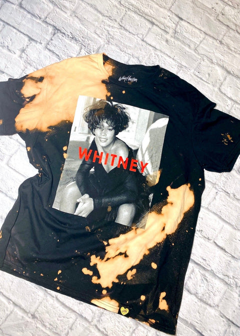 whitney houston bleach dye t shirt on a white brick background