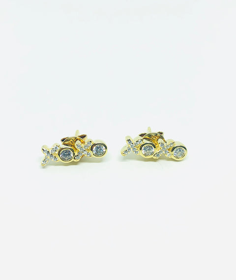 gold and faux diamond earrings in the shape of "xoxo" on a white background